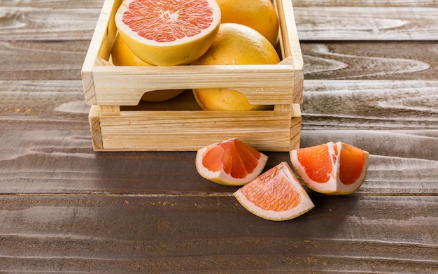 Pomelo rojo rubí fresco en caja de madera.