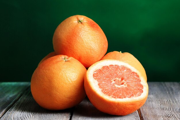 Pomelos maduros en tablero de madera sobre fondo de color oscuro