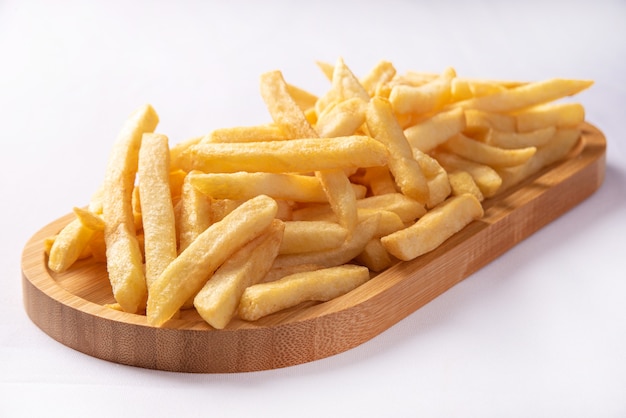 Pommes Frites auf einen langen Holzteller gelegt.