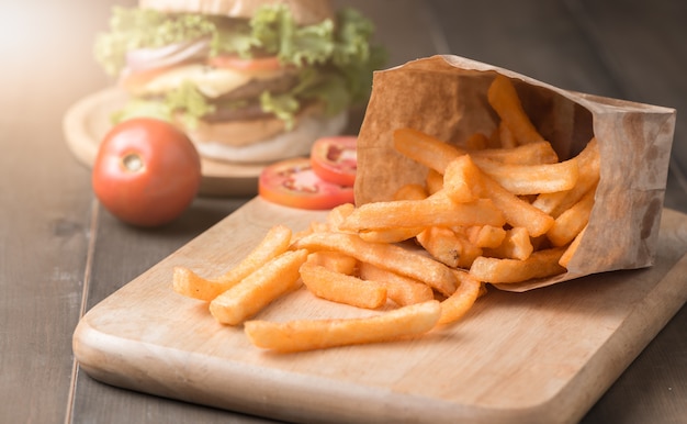 Pommes-Frites auf hölzernem Block und dunklem hölzernem Hintergrund