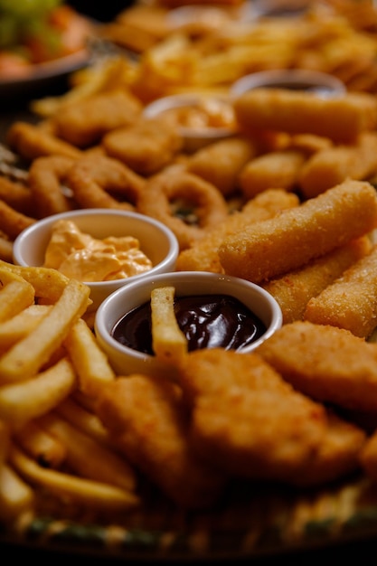 Foto pommes frites hähnchen- und fischnuggets käsesauce bbq-sauce essen auf dem teller