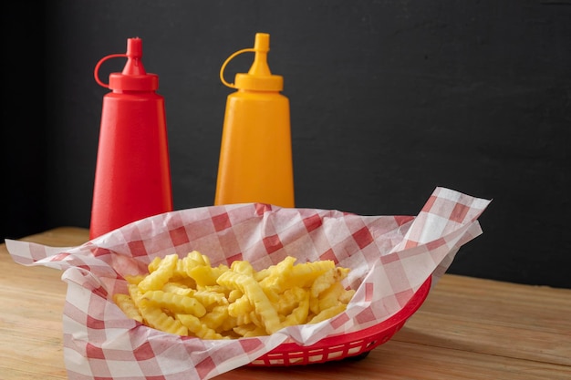 Pommes Frites im Korb mit Ketchup und Senf als Beilage