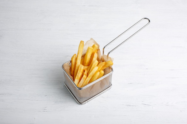 Pommes frites in einem Korb Fast Food auf weißem Hintergrund