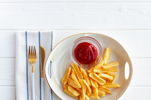 Pommes Frites Kartoffeln in Teller mit Sauce auf Holztisch