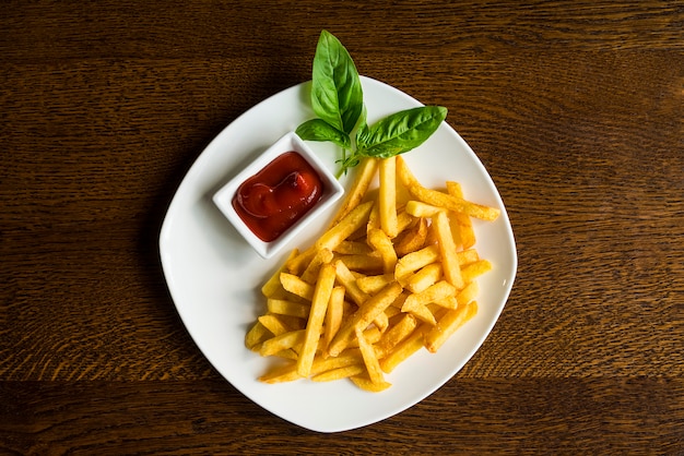 Pommes-Frites mit Soße auf einer weißen Platte