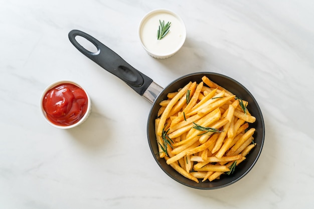 Pommes Frites oder Kartoffelchips mit Sauerrahm und Ketchup