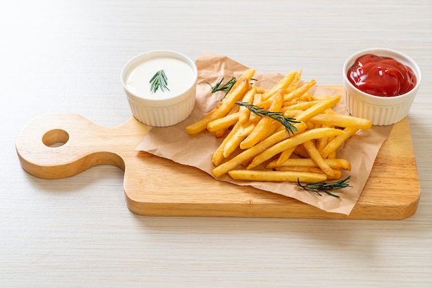 Pommes Frites oder Kartoffelchips mit Sauerrahm und Ketchup