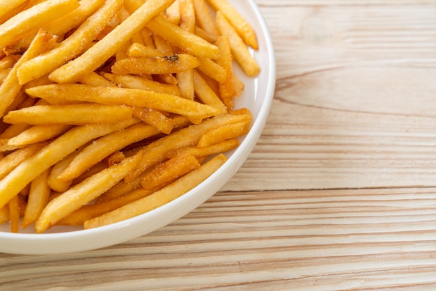 Pommes Frites oder Kartoffelchips mit Sauerrahm und Ketchup