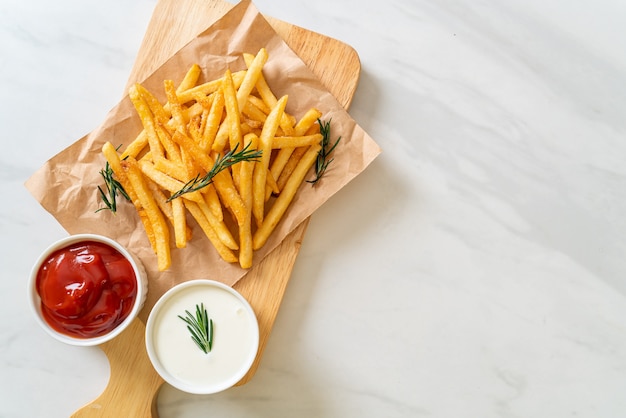 Pommes Frites oder Kartoffelchips mit Sauerrahm und Ketchup