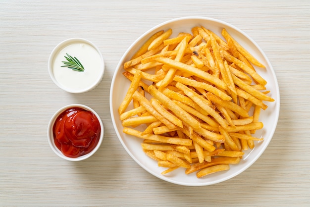 Pommes Frites oder Kartoffelchips mit Sauerrahm und Ketchup