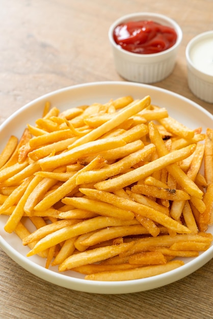 Pommes Frites oder Kartoffelchips mit Sauerrahm und Ketchup