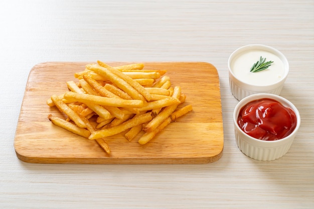 Pommes Frites oder Kartoffelchips mit Sauerrahm und Ketchup