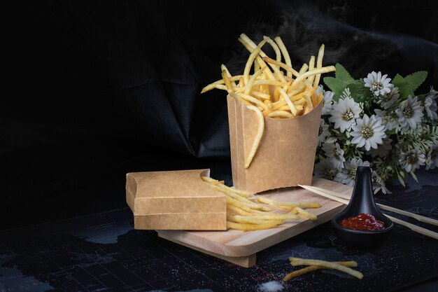 Pommes frittiert gelb auf schwarzem Hintergrund mit Rauch