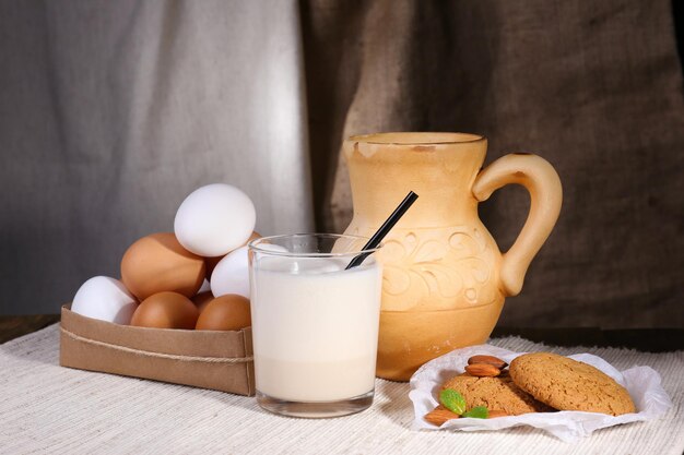 Ponche de huevo con leche y huevos sobre mesa y fondo de tela