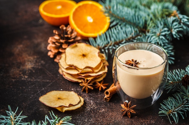 Ponche de huevo de Navidad en un vaso en el fondo de Navidad, espacio de copia.