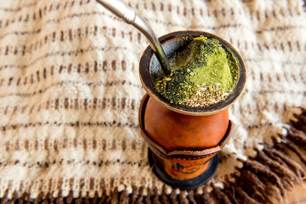 Poncho de tradición gaucha y chimarrao de yerba mate