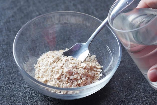 Poner agua en copos de avena cruda en un recipiente