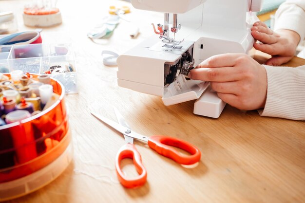 Poner el carrete de metal en la máquina de coser