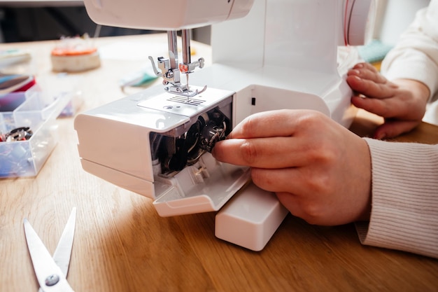 Poner el carrete de metal en la máquina de coser