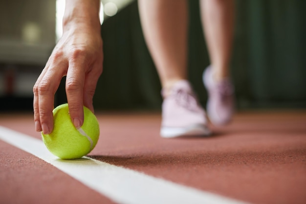 Poner la pelota de tenis en la línea de fondo