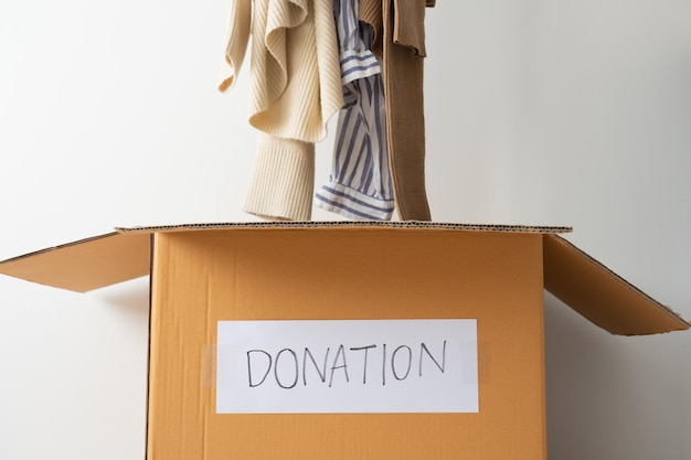 Poner ropa usada en la caja de cartón para donación Compartiendo el concepto de esperanza de donación