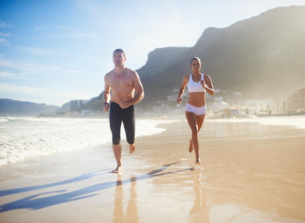 Ponerla a correr Toma de cuerpo entero de una pareja corriendo por la playa