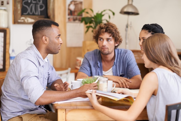 Ponerse al día con viejos amigos Foto de un grupo de amigos hablando en un café