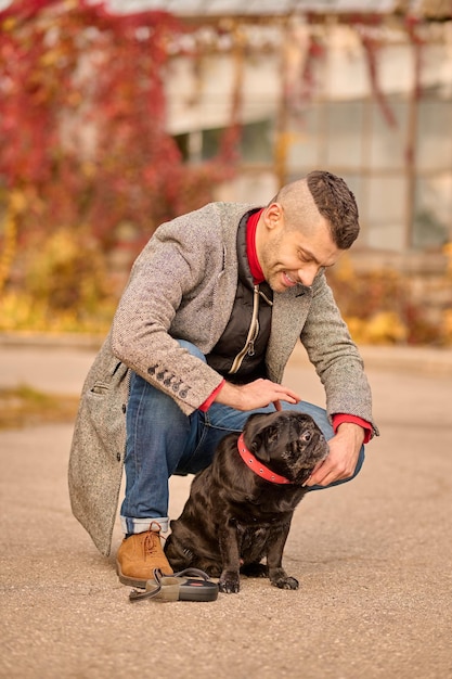 Ponerse un collar de perro. El dueño de una mascota pone un collar de perro en el cuello de su mascota