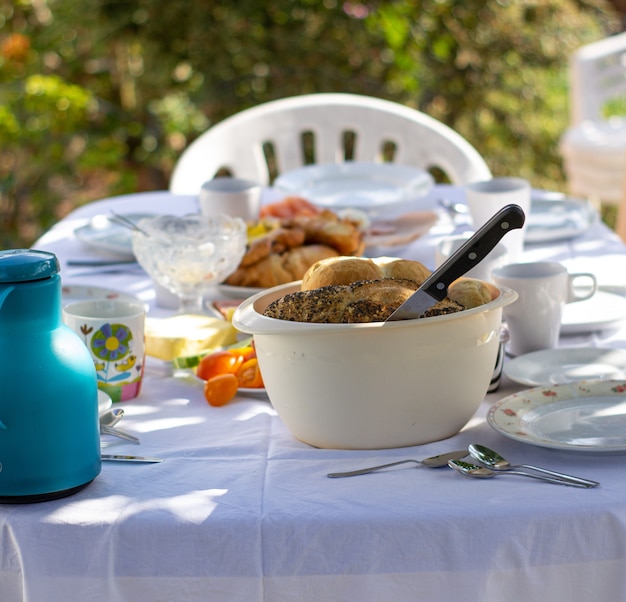 Ponha a mesa na natureza. Toalha de mesa branca. Festa casual ao ar livre na primavera ou verão no jardim preparada para o almoço e jantar.