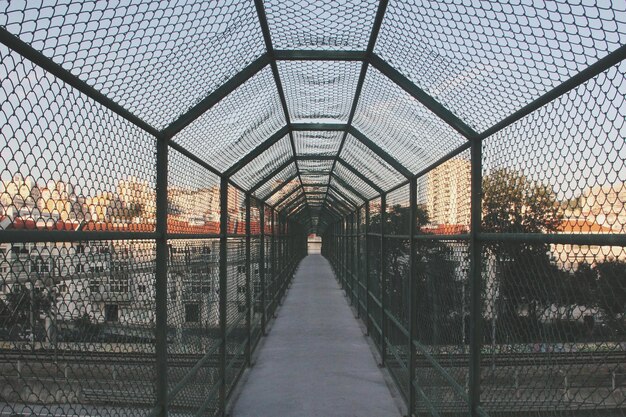 Foto ponte contra o céu visto através da cerca de cadeia