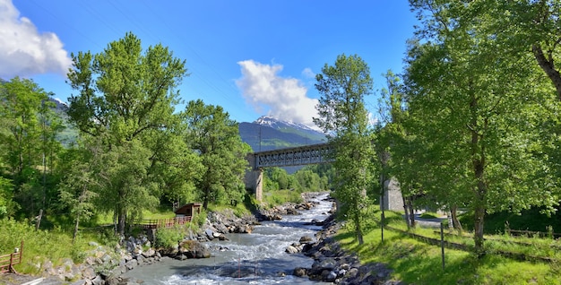 Ponte cruzando as águas correntes de um rio em um vale de tarentaise nos Alpes franceses