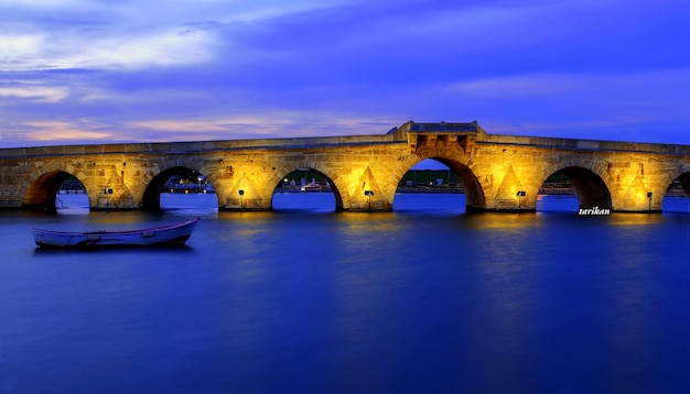 Ponte de arco iluminada sobre o rio contra o céu