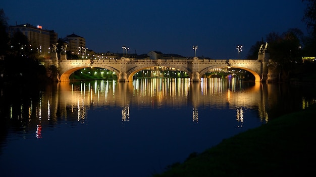 Ponte de arco sobre o rio contra o céu à noite