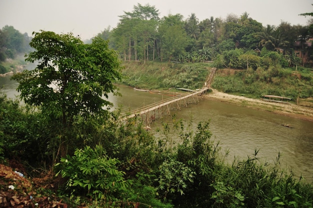 Foto ponte de bambu para o povo do laos e viajantes estrangeiros caminhando visita de viagem cruzando maenam khong ou rio mekong ir para pequena ilha na cidade de luangprabangon lao em luang prabang laos