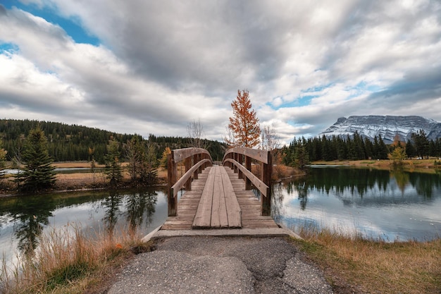 Ponte de madeira com o monte rundle no outono parque público em cascade ponds, parque nacional de banff, canadá