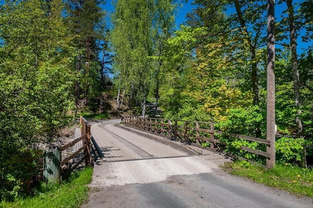 Ponte de madeira sobre o rio para pedestres e carros Paisagem em um dia ensolarado de primavera Nomeveski