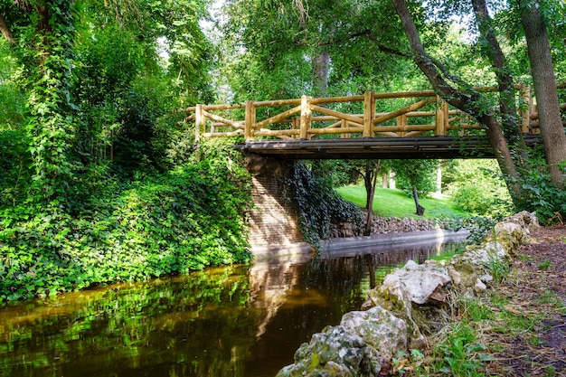 Ponte de madeira sobre um pequeno riacho no parque público Retiro, Madrid.