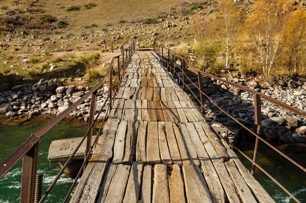 Ponte de madeira sobre um rio de montanha,