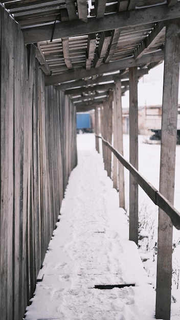Ponte de madeira velha e vazia abstrata fechada e com neve no inverno ou na primavera