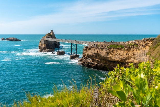 Ponte de pedestres de madeira sobre o mar em Biarritz, Rocher de la Vierge no verão