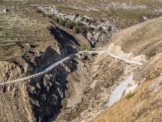 Ponte de pedra e montanha serpentina nas montanhas. Vista aérea