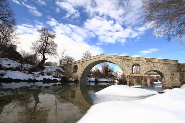 Ponte de pedra sobre o riacho invernal