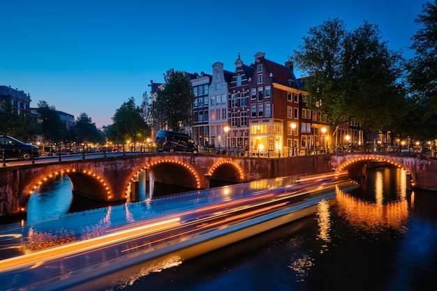 Ponte do canal de Amterdam e casas medievais à noite