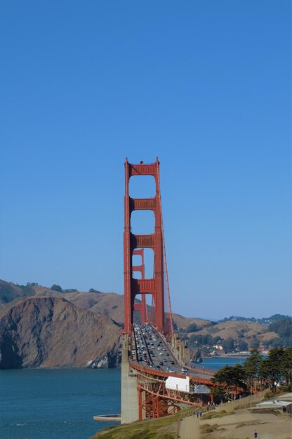 Ponte do portão dourado sobre o mar contra o céu azul