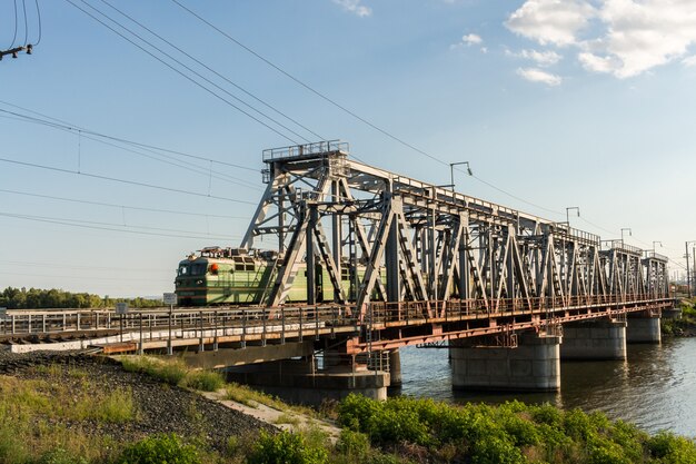 Ponte ferroviária através do rio Volga e trem de carga é movi