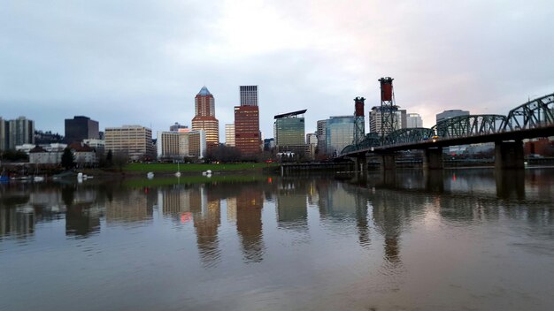 Foto ponte hawthorne sobre o rio contra edifícios e céu na cidade ao anoitecer