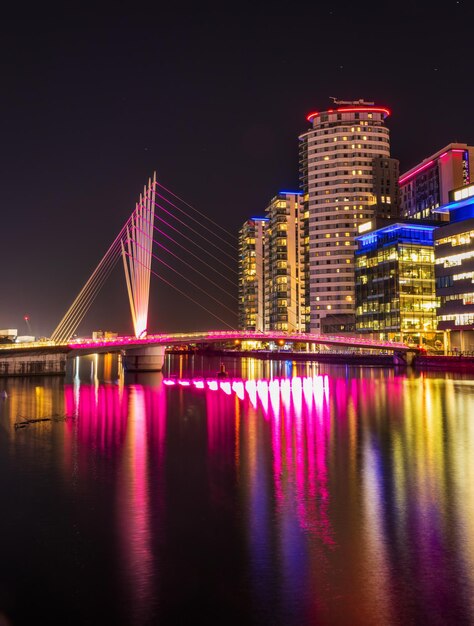 Foto ponte iluminada sobre o rio à noite em manchester, inglaterra salford quays media city