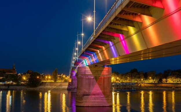 Foto ponte iluminada sobre o rio contra o céu à noite