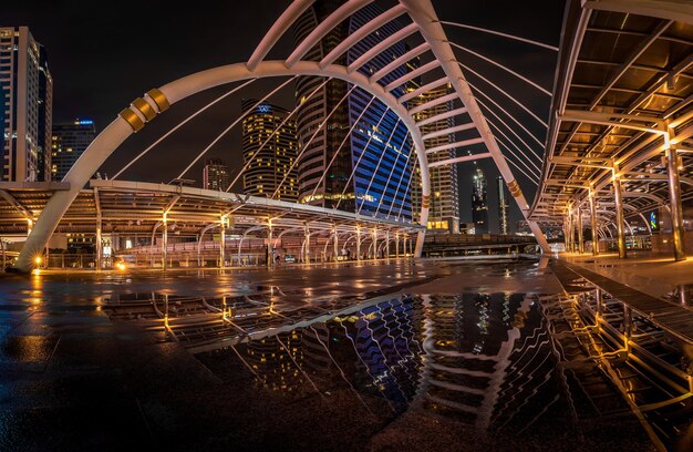 Ponte iluminada sobre o rio na cidade à noite