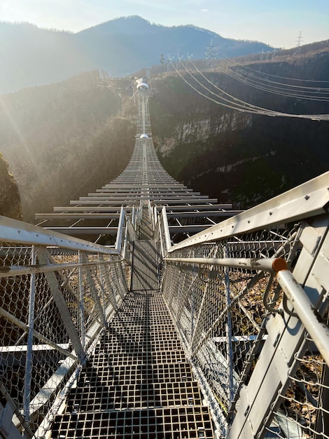 Ponte metálica suspensa no alto das montanhas do outro lado do desfiladeiro Sochi Rússia